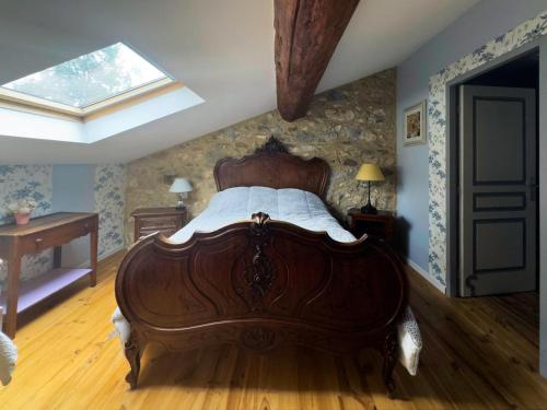 a bedroom with a wooden bed and a skylight at L'Oustal de l'Annetta Chambres et Tables d'Hôtes in Comus