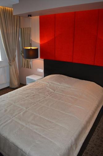 um quarto com uma cama grande e uma cabeceira vermelha em Mokomasis svetingumo centras em Utena