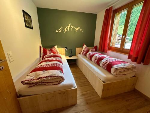 a room with two beds with red and white pillows at Ferienhaus Elisabeth - zentral, geräumig und familienfreundlich in Malbun