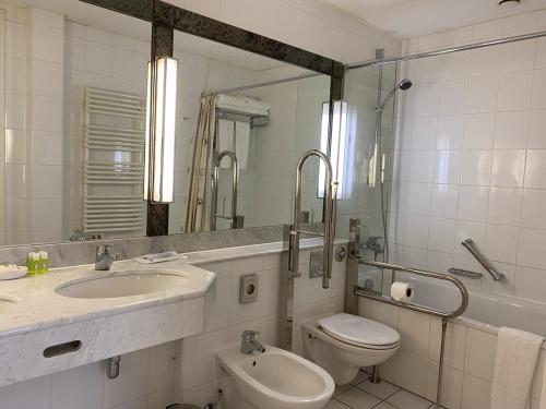 a bathroom with a sink and a toilet and a mirror at Natsionalny Hotel in Kyiv
