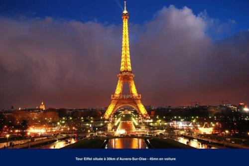 a view of the eiffel tower at night at Amman Studio avec terrasse au cœur du village impressionniste in Auvers-sur-Oise