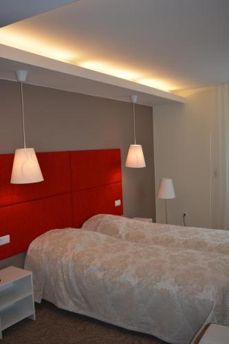 um quarto com duas camas e duas luzes em Mokomasis svetingumo centras em Utena