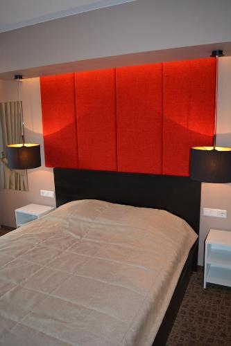 1 dormitorio con 1 cama grande con cabeceros rojos en Mokomasis svetingumo centras, en Utena