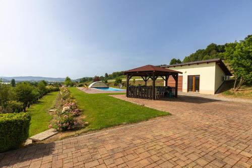 a brick patio with a gazebo and a pool at Luxury 10-bed villa with view pool playground in Horní Planá