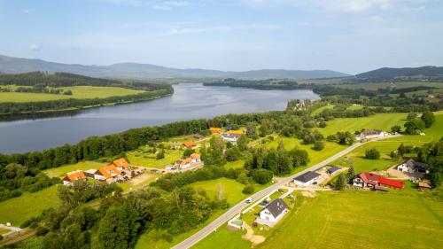 an aerial view of a village next to a river at Luxury 10-bed villa with view pool playground in Horní Planá