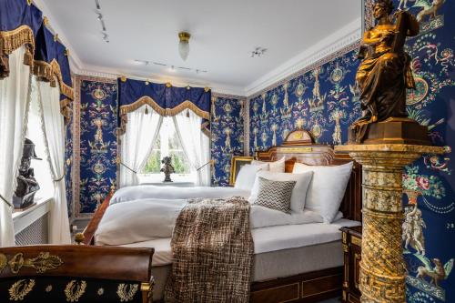 a bedroom with blue walls and a bed with a statue at Ramme Fjordhotell - Unike Hoteller in Hvitsten