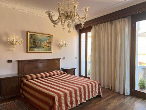 una camera da letto con un letto e un lampadario di Hotel San Luca Venezia a Venezia