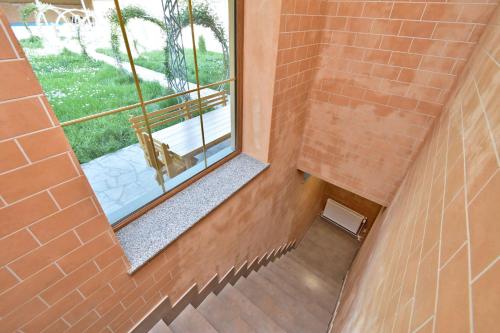 Una escalera con una ventana en una pared de ladrillos. en Jrvezh Family House, en Jrvezh