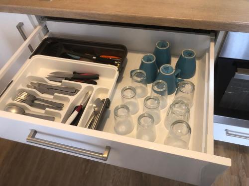a drawer in a kitchen with glasses and utensils at Appartement 2 chambres cosy centre ville historique in Orléans