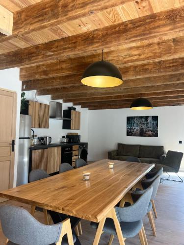 Un comedor con mesa y sillas de madera. en Gîte de Condeiss, en Condeissiat