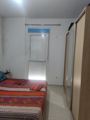 a room with two beds and a window at Big family house in Birkhadem