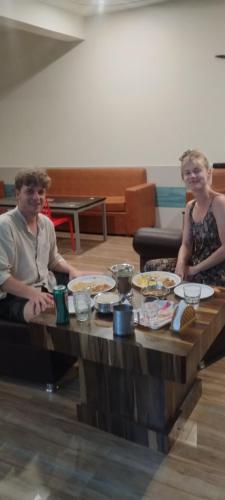 a man and woman sitting at a table with food at Sunrise Homestay Agra Near Taj Mahal in Agra