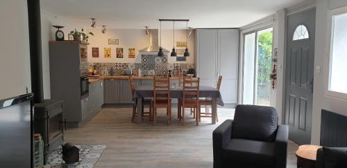 une cuisine et une salle à manger avec une table et des chaises dans l'établissement LA PETITE BICOQUE au fond du jardin, à Quillan