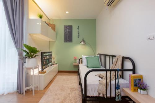 a small bedroom with a bed with green walls at Cozy room near Night bazaar in Chiang Mai
