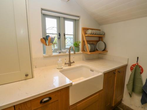a kitchen with a sink and a window at Cobbles Cottage in Heptonstall