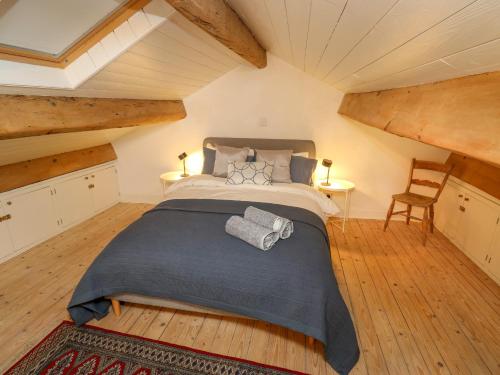 a bedroom with a large bed in a attic at Cobbles Cottage in Heptonstall