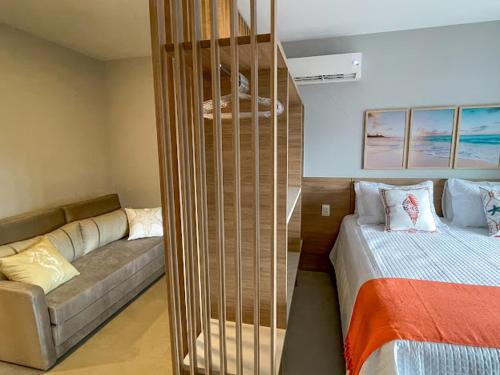 a room with a bed and a couch next to a bed at Costa Solar Lagoa in Florianópolis
