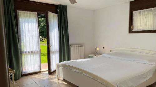 una camera da letto con un letto bianco e una finestra di Magia del Lago a Stresa