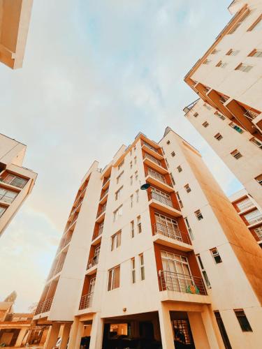 a tall white building with windows on it at Racecourse gardens furnished apartments in Nairobi