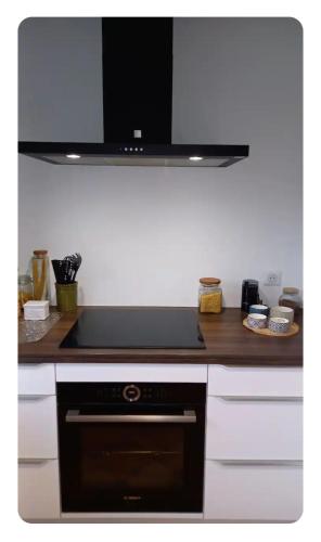 Il comprend une cuisine équipée d'un four avec plaques de cuisson noires. dans l'établissement Chambre Bleue, lit double 2 personnes, Maison en plein coeur du Parc Régional du Vexin, à Hérouville