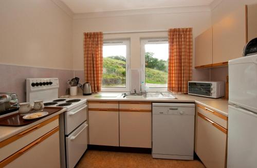 a kitchen with white appliances and a window at Blarghour Farm Cottages in Ardchonnell