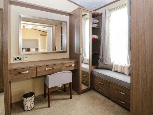 a bathroom with a vanity and a mirror at Lodge 26, Fishing Lakes in Stowmarket