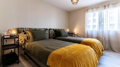 une chambre avec un lit et une grande fenêtre dans l'établissement La Cerisaie, à Talant