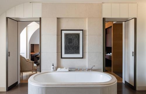 a bath tub in a bathroom with a mirror at Four Seasons Hotel des Bergues Geneva in Geneva