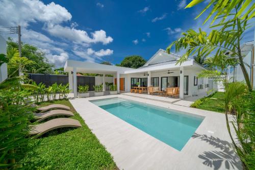 a swimming pool in the backyard of a house at Brand New 4BR Balinese Style Pool Villa Kaia just 5 min drive from NaiHarn Beach in Rawai Beach
