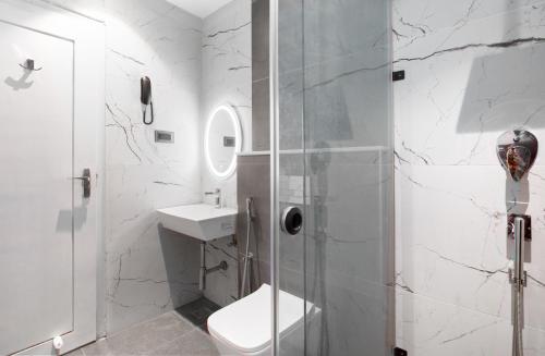 a bathroom with a shower and a toilet and a sink at 44 Oasis in Chennai
