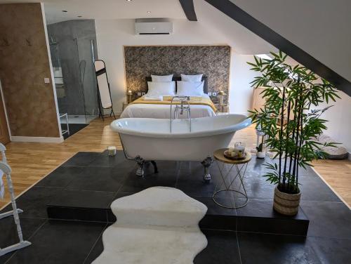 a bedroom with a bath tub and a bed at La Suite - Villa Valmy - Hypercentre - Gare SNCF in Montluçon