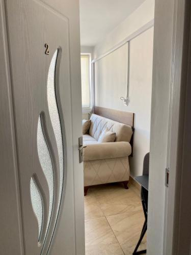 a door leading to a living room with a couch at Complex Omnia - Apartamente Husi in Huşi