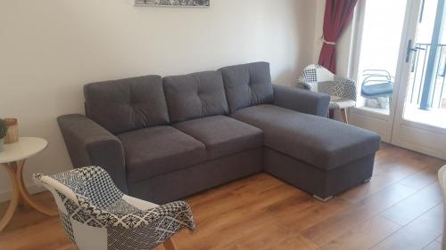 a living room with a couch and a table and chairs at Gîtes Les 3 Tours 2 in Carcassonne