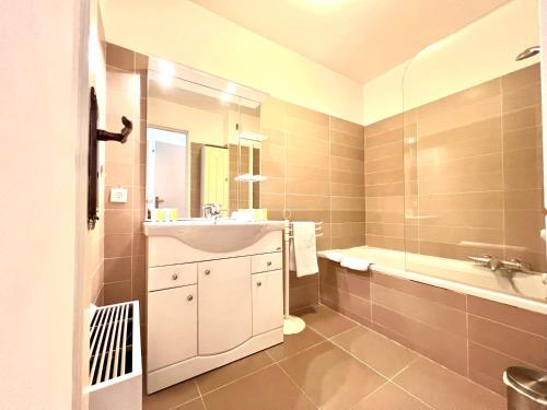 une salle de bain avec un lavabo et une baignoire dans l'établissement A077 Appartement agreable avec vue mer et palais des festivals, à Cannes