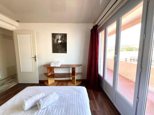 une chambre avec un lit, une table et une fenêtre dans l'établissement A077 Appartement agreable avec vue mer et palais des festivals, à Cannes