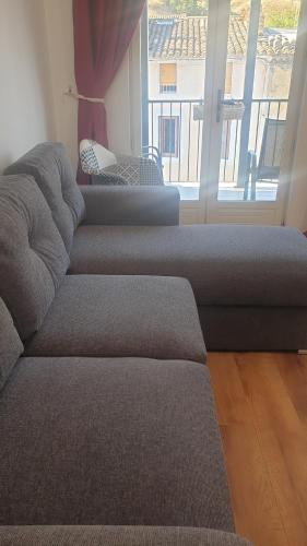 a living room with a couch and a large window at Gîtes Les 3 Tours 2 in Carcassonne