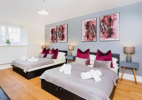 two beds in a room with red and white pillows at Barn near york with hot tub in York