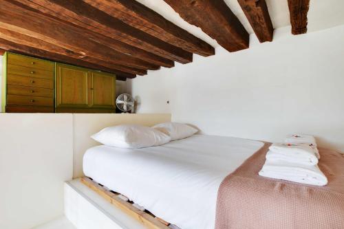 - une chambre avec un lit blanc et des plafonds en bois dans l'établissement Modern flat - 1BD-4P - Arts et Métiers, à Paris