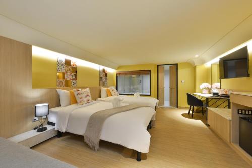 a large bedroom with a large bed and a desk at Kastel Bangkok Hotel in Bangkok