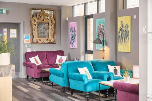 a waiting room with blue chairs and purple couches at The Lodge Hotel in Newbury