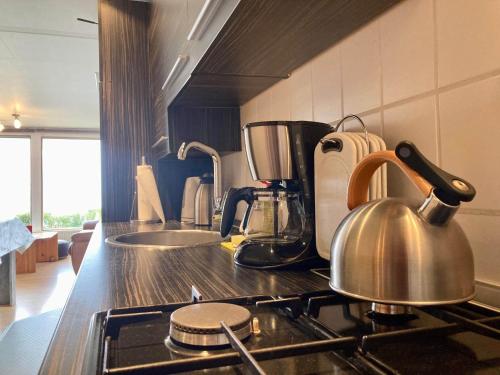 a tea kettle on a stove in a kitchen at Meerzicht, 6-persoons aan het Lauwersmeer Friesland in Anjum