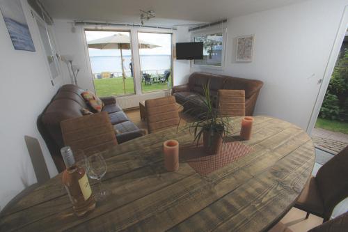 a wooden table in a living room with a couch at Meerzicht, 6-persoons aan het Lauwersmeer Friesland in Anjum