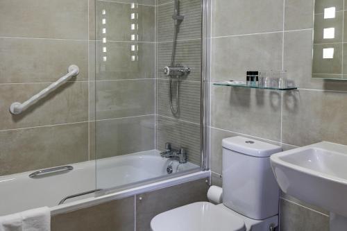 a bathroom with a shower and a toilet and a sink at Best Western Princes Marine Hotel in Brighton & Hove