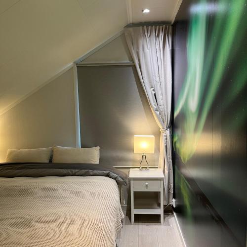 a bedroom with a bed and a table with a lamp at Leilighet i Stamsund, Lofoten in Rishaugen