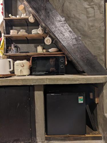 a microwave sitting on top of a counter at Ivy Coffee Farm - Cabin House in Ðưc Trọng