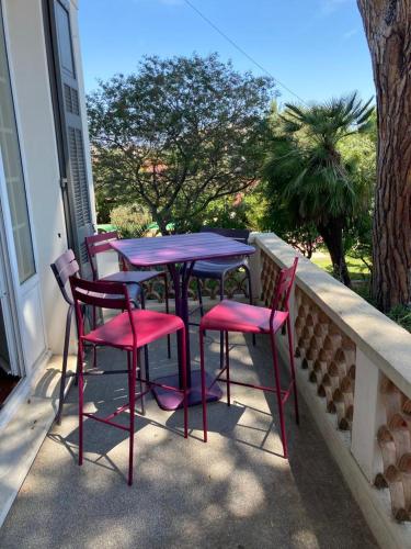 un ensemble de tables et de chaises sur un balcon dans l'établissement magnifique villa avec piscine, à Antibes
