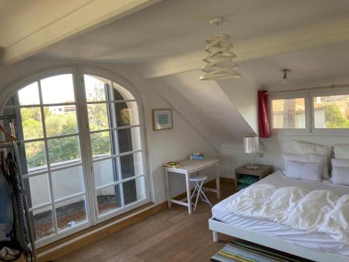 une chambre avec un lit, un bureau et des fenêtres dans l'établissement magnifique villa avec piscine, à Antibes