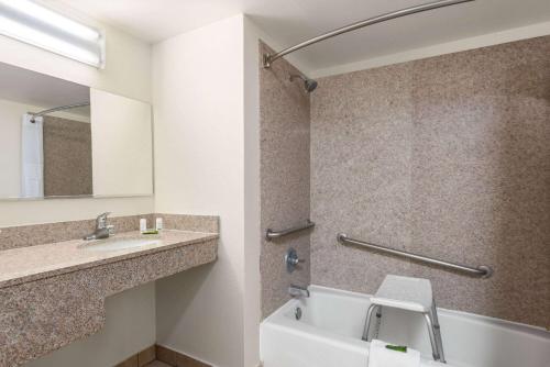 a bathroom with a sink and a tub and a toilet at Ramada by Wyndham Kingman in Kingman