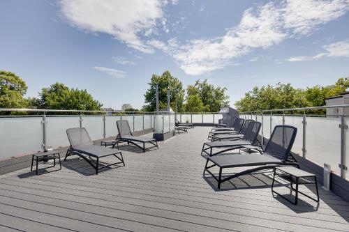 a row of chairs sitting on top of a deck at Villa Meduza in Kołobrzeg