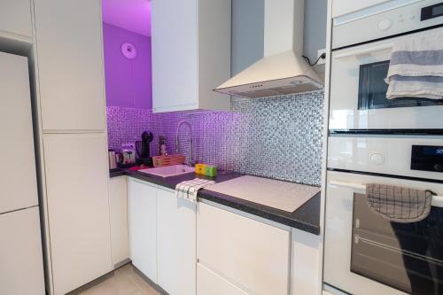 une cuisine avec des placards blancs et du carrelage violet dans l'établissement Appartement cosy et lumineux 2 pieces 10 mn de gare de Lyon, à Alfortville